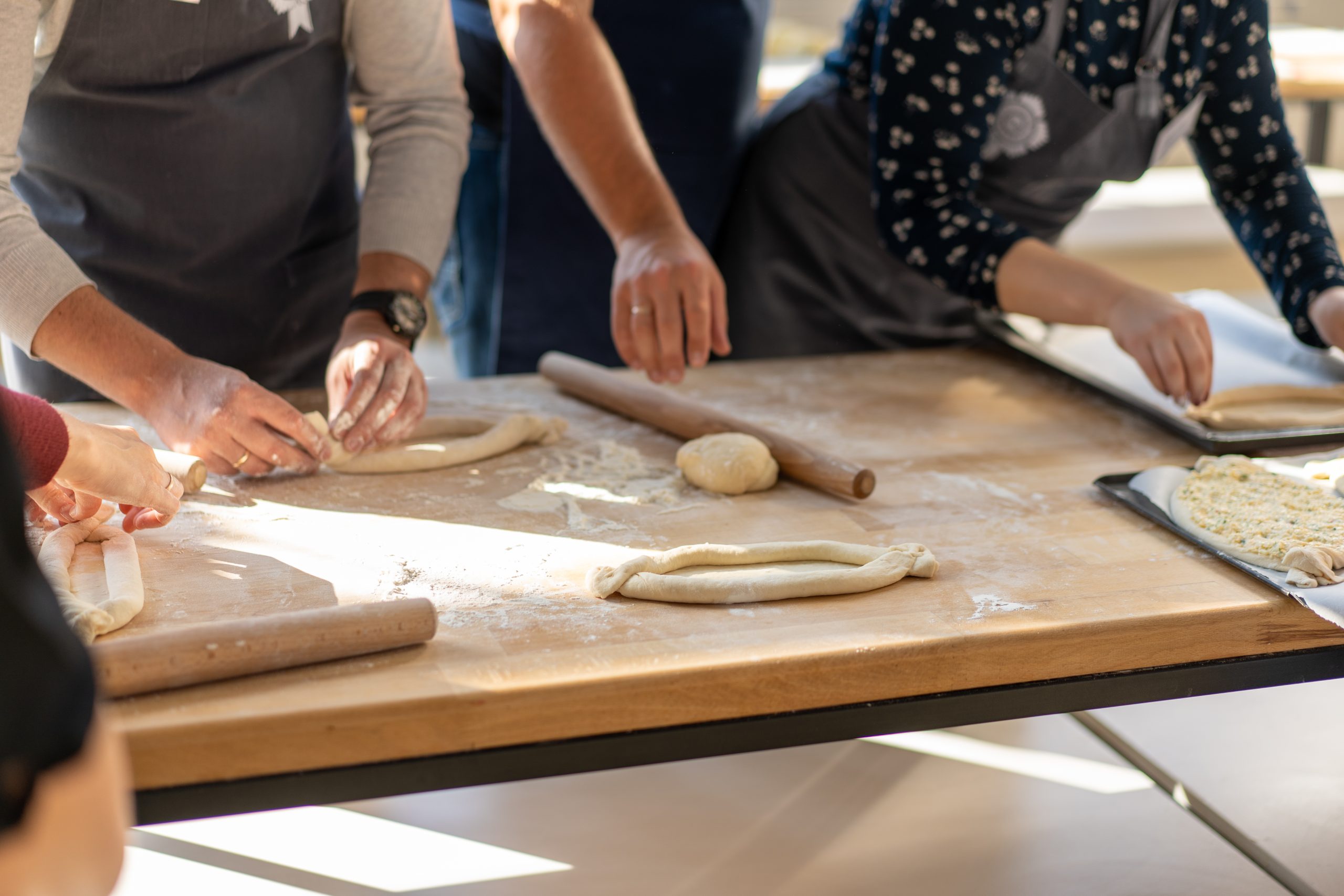 Culinary master class. Closeup of people hands preparing khachapuri. Traditional georgian cheese bread. Georgian food