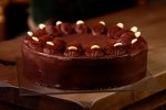 Chocolate cake above with fresh cocoa on wooden table
