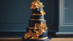 Elegant White and Gold Wedding Cake Surrounded by Flowers