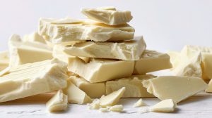 Stacked Chunks of Broken White Chocolate on a Light Background
