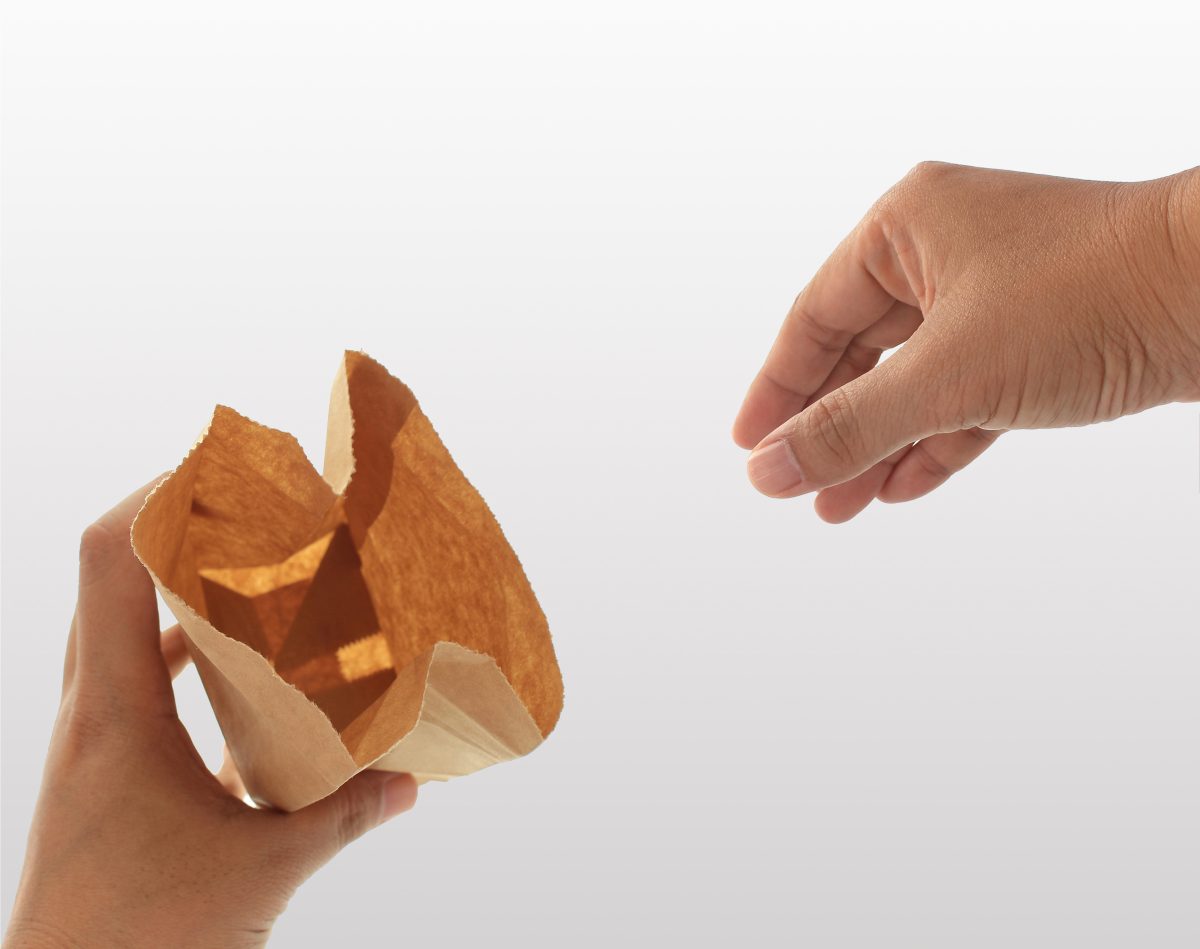 hand holding a brown paper bag