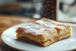 Chef sprinkling icing sugar on apple pie dessert