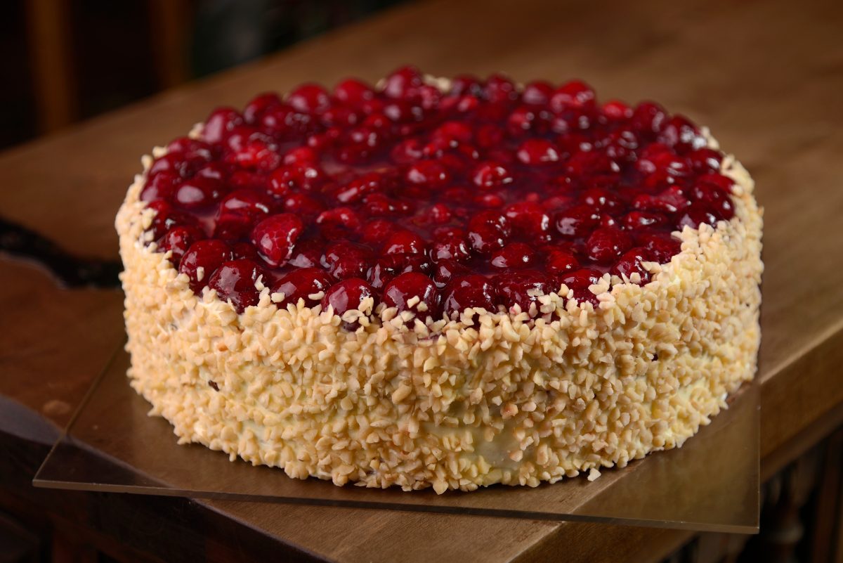 Raspberry cake with nuts on wooden table