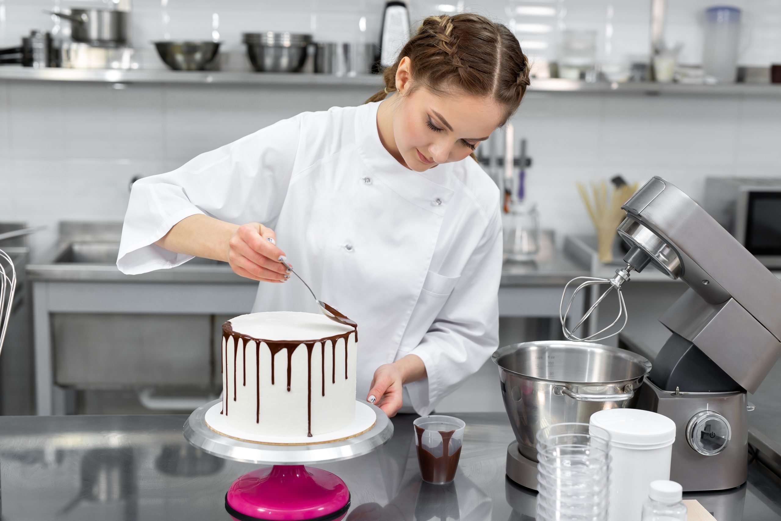 Pastry chef decorates the cake with chocolate streaks